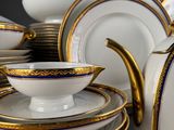 a lot of white and gold plates and cups