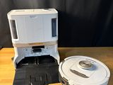 une photo montrant un robot aspirateur et un micro-ondes posés sur une table