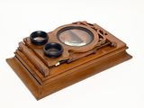 a small wooden box with a magnifying glass on it