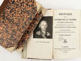 an old book sitting on top of a table next to a book with a picture of a man on it