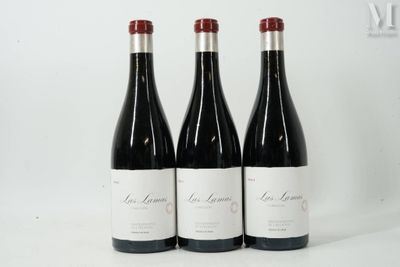 three bottles of red wine are lined up on a white surface
