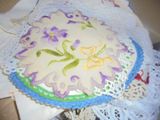 un gâteau blanc orné de fleurs violettes, posé sur un napperon