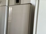 several white refrigerators are lined up in a row in a kitchen
