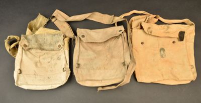 three old canvas bags sitting next to each other on a table