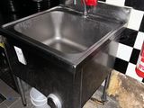 un évier dans un coin d'une cuisine aux murs à carreaux noirs et blancs