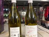 deux bouteilles de vin posées sur une table l'une à côté de l'autre