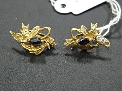 paire de boucles d'oreilles dorées ornées de pierres noires et blanches