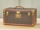 a brown and tan suitcase sitting on a wooden table