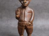 une vieille figurine en bois représentant un homme avec un chapeau sur la tête