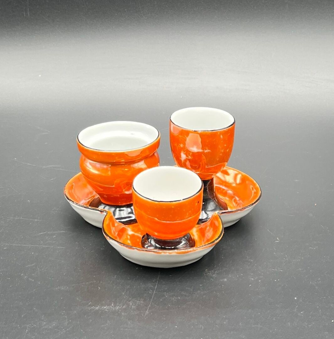FRANCE. Ensemble de trois coquetiers à taille différente en faïence à fond blanc, orange et noir. (manque de peinture...