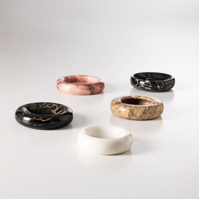 quatre bols en marbre de couleurs différentes posés sur une surface blanche