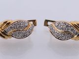 a pair of gold and diamond earrings on a white surface