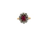 a close up of a gold ring with a red stone