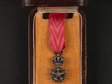 medal in a case on a black background with a red ribbon
