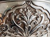 a silver bowl with a decorative design on it