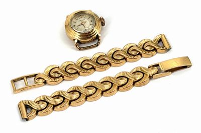 a gold watch and a gold bracelet on a white surface