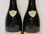 deux bouteilles de vin posées sur une table l'une à côté de l'autre