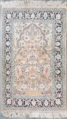 un tapis persan ancien avec un motif floral et des franges