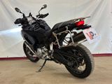 a black motorcycle parked in front of a white backdrop