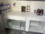 a small kitchen with a lot of bottles and containers on the counter