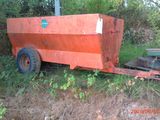 an orange trailer that is sitting in the grass