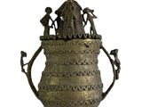 un grand vase en métal surmonté d'une statue