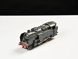 un petit train sur une surface blanche avec un fond noir