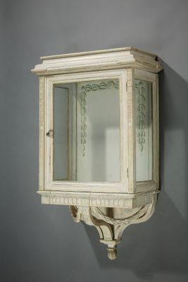 une petite armoire blanche avec un miroir accroché au mur