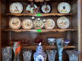 une vitrine en bois sur laquelle sont disposés de nombreux objets en verre