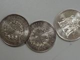 several silver coins are arranged in a row on a wall