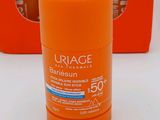 an orange bottle of sunscreen cream next to three orange boxes