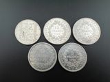 quatre types différents de pièces d'argent sur un fond noir