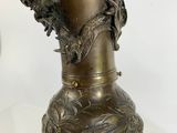 brass vase with dragon heads on it on a white background