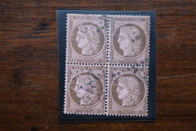 quatre timbres représentant des visages de femmes, posés sur une table