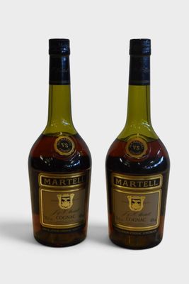 two bottles of wine sitting next to each other on a white surface