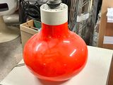 an orange vase sitting on top of a white table