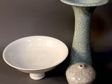 deux vases et un bol posés sur une table