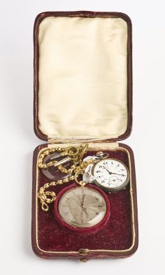 une petite boîte contenant une montre de poche et une chaîne en or