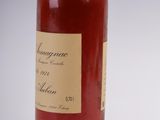 an old bottle of wine sitting on top of a white table