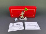 a box with a figurine of a man holding a leaf