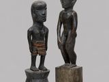 paire de statues en bois représentant un garçon et un autre garçon debout sur un socle