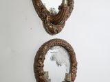 two mirrors are hanging on a wall in a room