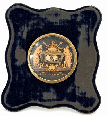 une assiette noire et dorée sur laquelle figure l'image d'un homme et d'une femme
