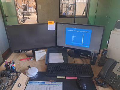 un bureau sur lequel sont posés deux écrans d'ordinateur et un clavier