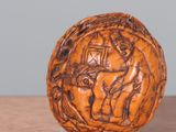 a wooden ball with carvings on it sitting on a table