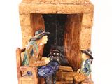 a figurine of a man and a woman sitting in front of a fireplace