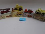 cinq camions miniatures et une boîte remplie de boîtes posées sur une table