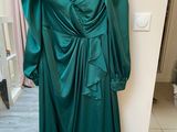 the dress is green and has a large bow on the back