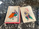 two boxes with paintings on them sitting on a table