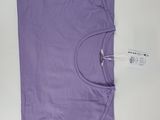 un t-shirt violet posé sur une surface blanche, avec une étiquette attachée dessus